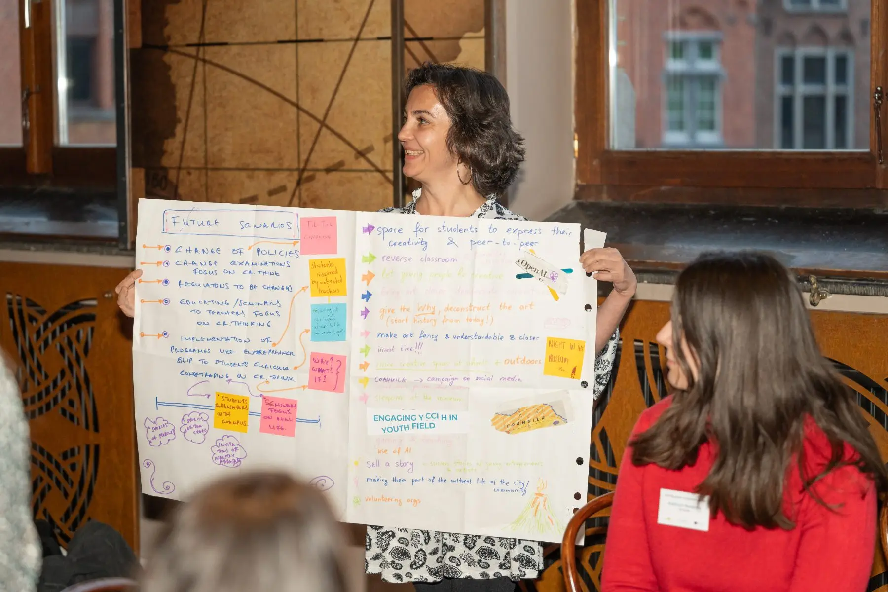 Una partecipante presenta il cartellone sugli scenari futuri elaborato dal suo gruppo