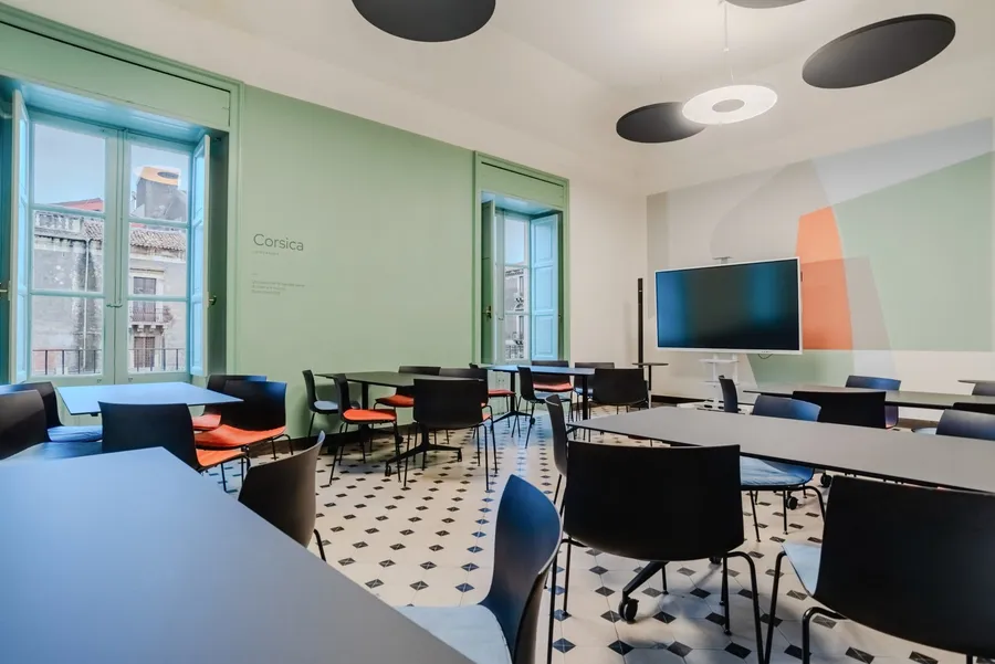 La sala Corsica di Isola a Catania, allestita a banchi, con lo schermo sul fondo