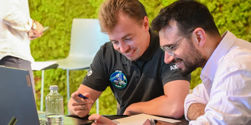 Two Water-Smart Agrifood Systems participants smiling as they work together at a table, at Isola