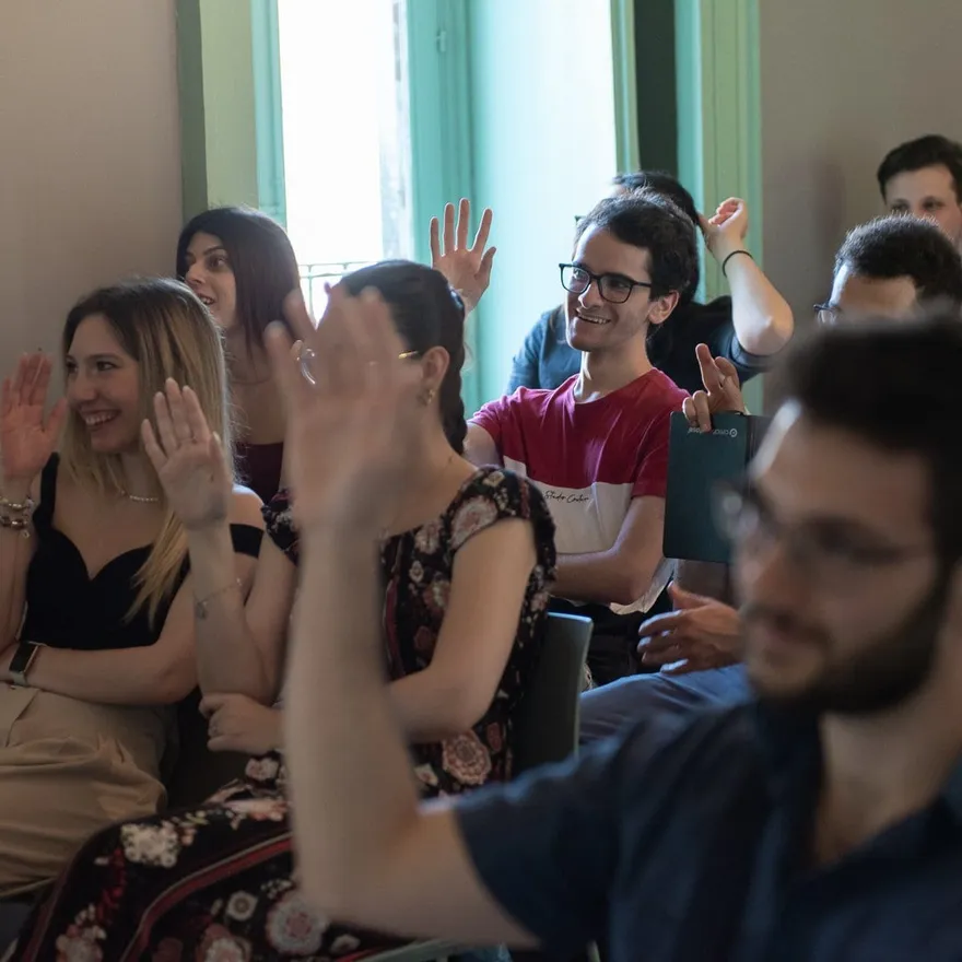 Il pubblico di un incontro alza la mano