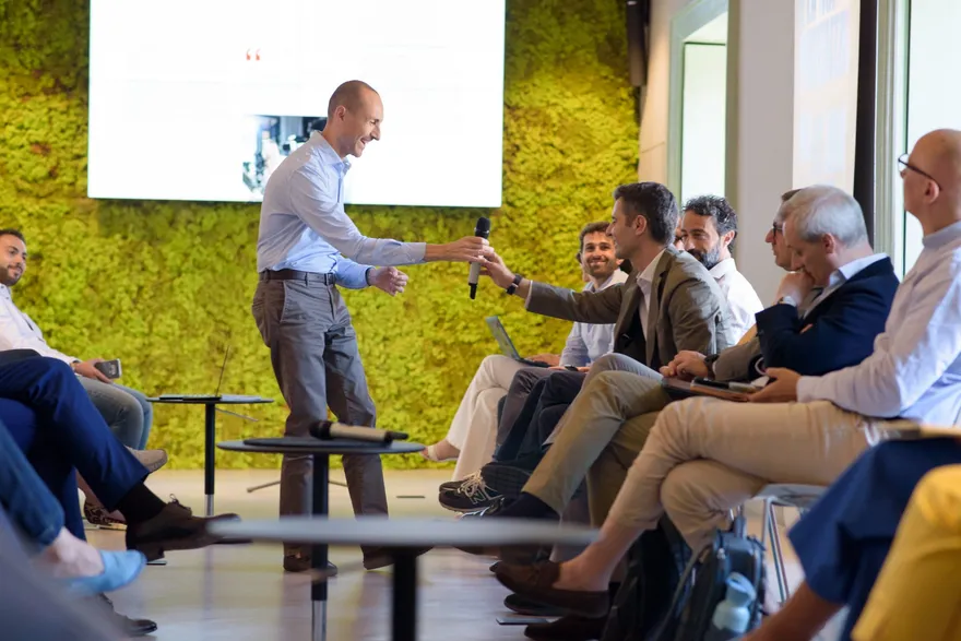 Il microfono passa tra il pubblico di un panel
