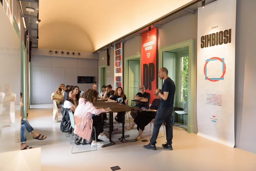 Un incontro attorno al tavolo con i banner dell’evento