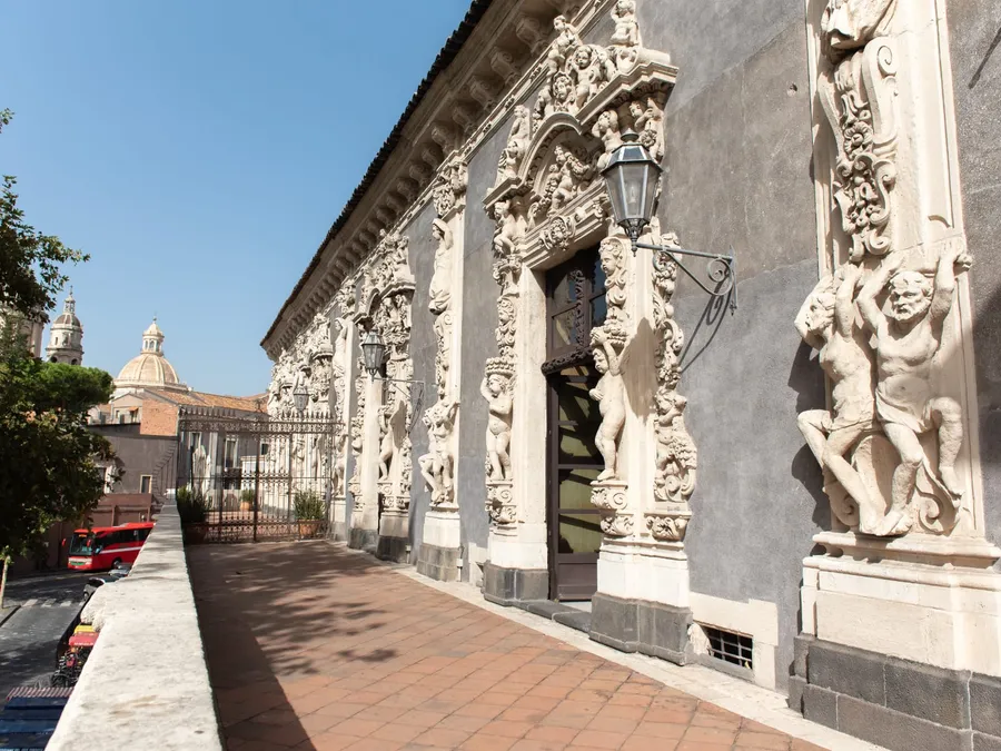 La facciata su via Museo Biscari, con i telamoni e le cupole del centro storico