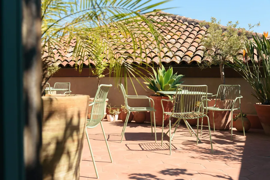 La terrazza Ibiza di Isola a Catania, tavoli e sedute all’ombra, tra i vasi di terracotta