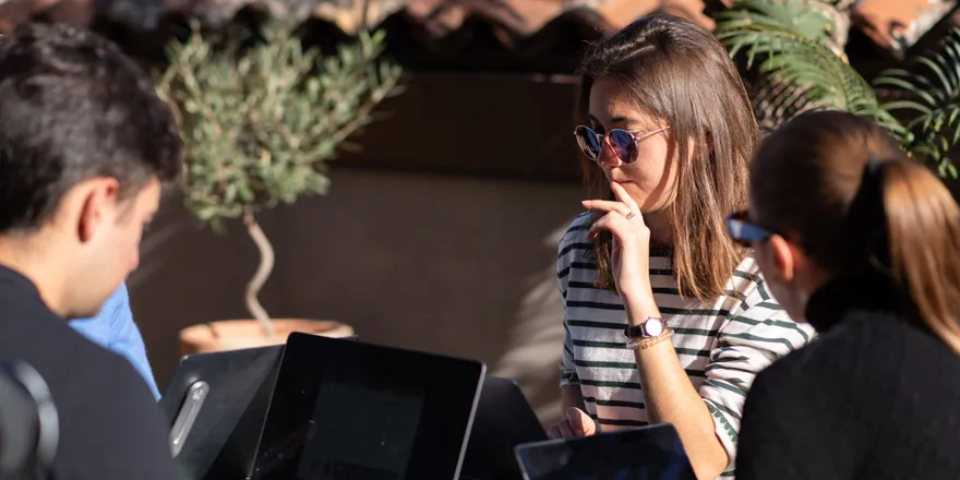 People working on laptops in the sun on the terrace of Isola Catania