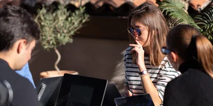 Persone al lavoro con i portatili sulla terrazza di Isola Catania, al sole