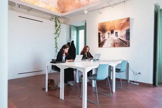 Sala di lavoro sotto le volte affrescate, con le fotografie alle pareti