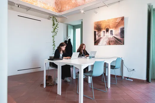 Sala di lavoro sotto le volte affrescate, con le fotografie alle pareti