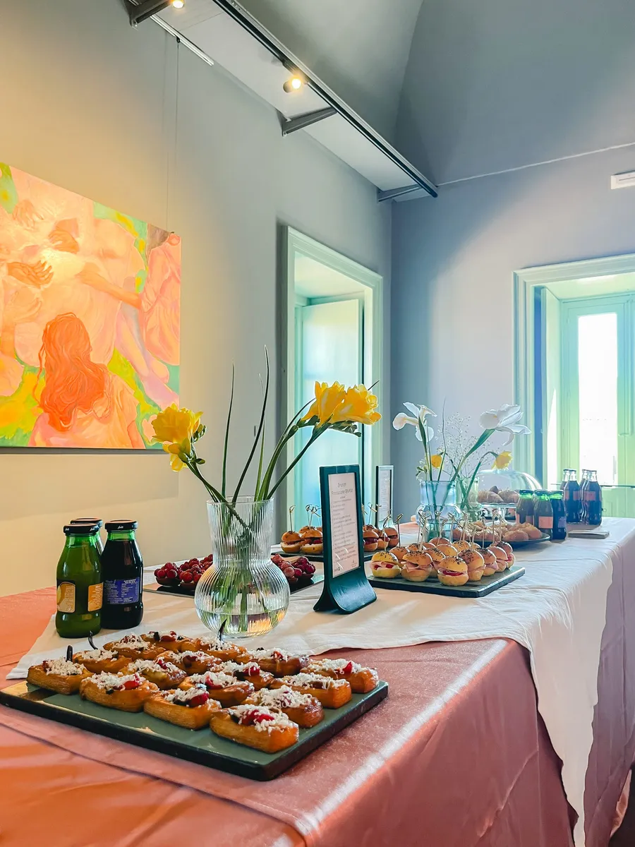 La sala Malta di Isola a Catania, il buffet di un brunch, tra le opere alle pareti